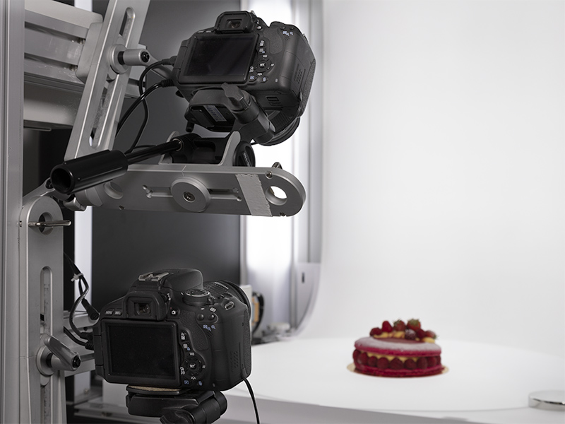 zoom on two cameras fixed on the multi arm to shoot a cake with multiple angles