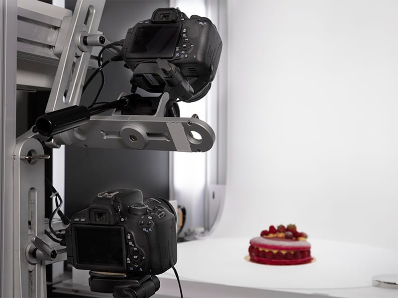 zoom on two cameras fixed on the multi arm to shoot a cake with multiple angles